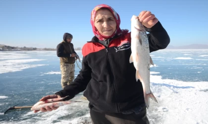 Eskimo usulü balık avlayan kadın, ekmeğini buzun altından çıkartıyor